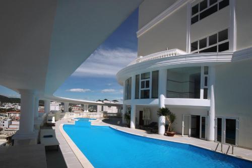 ein großes weißes Gebäude mit einem Pool in der Unterkunft Nha Trang Palace Hotel in Nha Trang