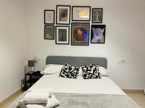 a bedroom with a bed with framed pictures on the wall at Cheap Studios Malaga Center in Málaga