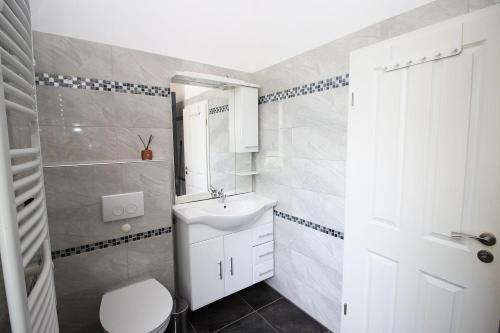 uma casa de banho com um lavatório branco e um WC. em Chic Apartment with Balcony em Wuppertal