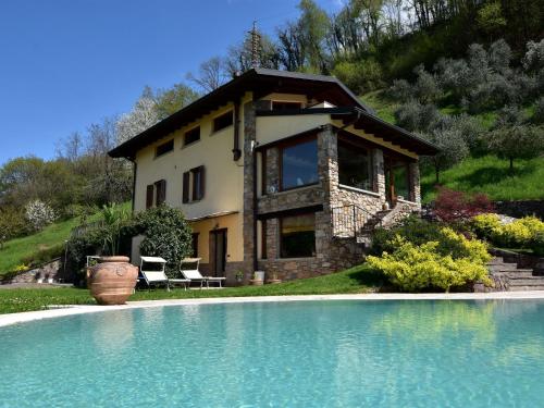 a house and a swimming pool in front of a house at Villa in Pisogne with pool garden and lake view in Pisogne