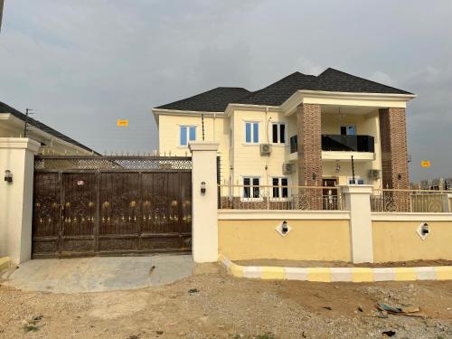 a white house with a gate and a fence at Havre Luxury Apartment in Abuja