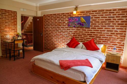 - une chambre avec un lit et un mur en briques dans l'établissement Kaji Chen, The Tourist Accommodation, à Pātan