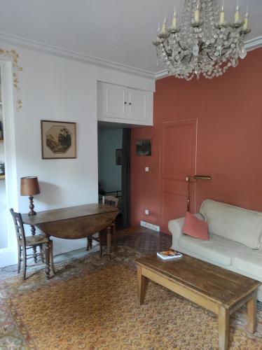 ein Wohnzimmer mit einem Sofa und einem Tisch in der Unterkunft Le Voltaire in Souppes-sur-Loing