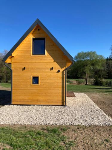 a small wooden house on a pile of gravel at Domek nad rzeką in Wierzchlas