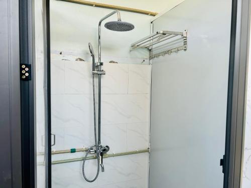 een douche in een badkamer met een glazen deur bij Majestic Hostel - Tour & Motorbike Rental in Ha Giang