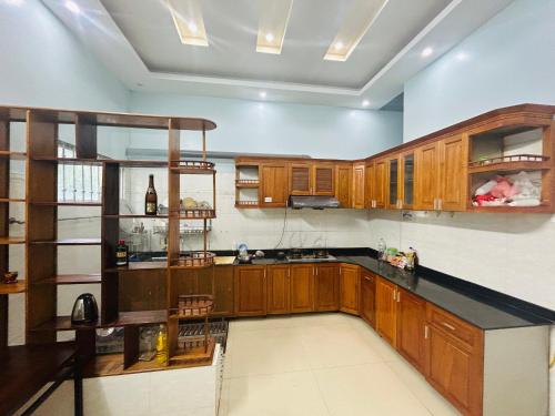a kitchen with wooden cabinets and a black counter top at Majestic Hostel - Tour & Motorbike Rental in Ha Giang