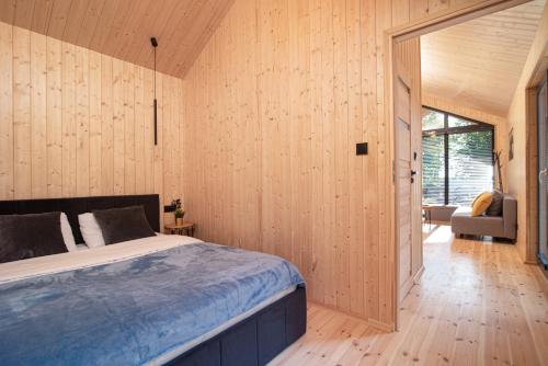 - une chambre avec un lit dans une pièce dotée de murs en bois dans l'établissement Stodoły Słona Zatoka, à Władysławowo