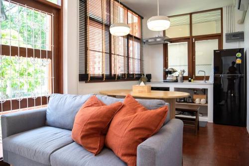 sala de estar con sofá azul y cocina en Ray's Home,3BR with front yard,walkable to Nimman en Chiang Mai