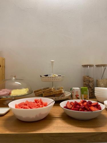 two bowls of fruit sitting on a wooden table at Olea b&b in Montecosaro