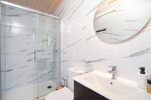 a bathroom with a shower and a sink and a mirror at Stodoły Słona Zatoka in Władysławowo