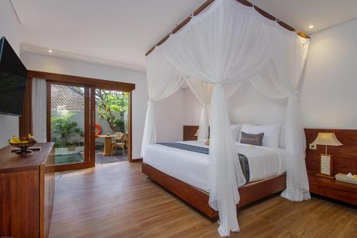 a bedroom with a bed with a canopy at Reswaha Villas by Pramana Villas in Ubud