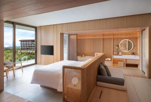 a bedroom with a large bed and a bathroom at The Taikang Sanya, a Tribute Portfolio Resort in Sanya