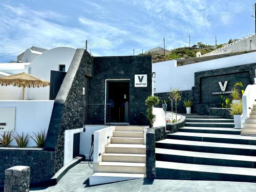 - un bâtiment noir et blanc avec des escaliers devant dans l'établissement Venus Sunrise Suites & Villas, à Vourvoúlos
