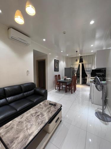 sala de estar con sofá negro y mesa en Mộc Homestay VIP en Ấp Ðông An (1)