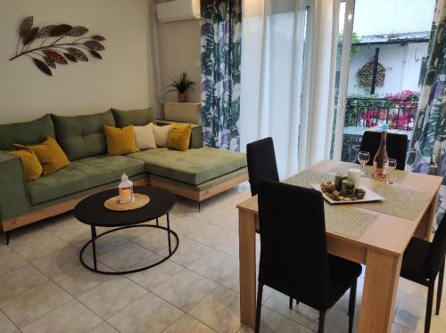 uma sala de estar com um sofá verde e uma mesa em TRAVELLERS HOUSE em Volos
