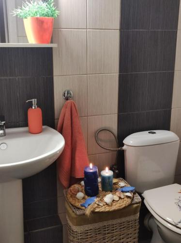 a bathroom with a sink and a toilet and candles at TRAVELLERS HOUSE in Volos