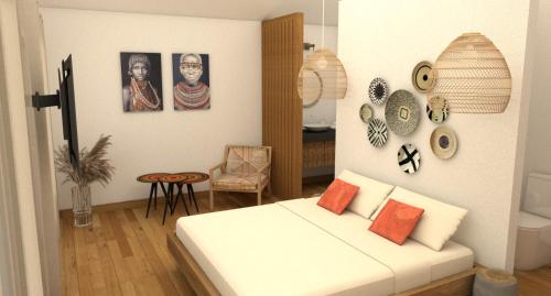 Habitación con cama blanca y cuadros en la pared. en Heritage Ecolodge, en Le Tampon