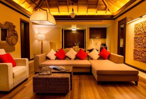 a living room with a couch and red pillows at STORY Seychelles in Beau Vallon