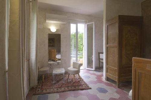 Antica Casa Santa Maria في Pomaro Monferrato: ممر مع غرفة بها كرسي ومرآة