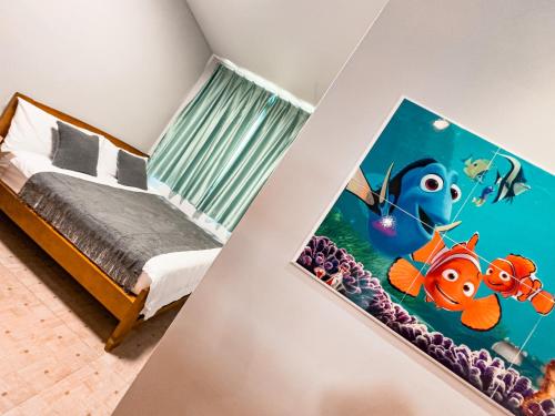 a bedroom with a bed with a fish painting on the wall at 炎島 & 莎蔓民宿Salman in Green Island