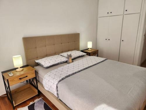 ein Schlafzimmer mit einem großen Bett und zwei Nachttischen in der Unterkunft Retro Panoramic Rooftop vipgreece in Athen