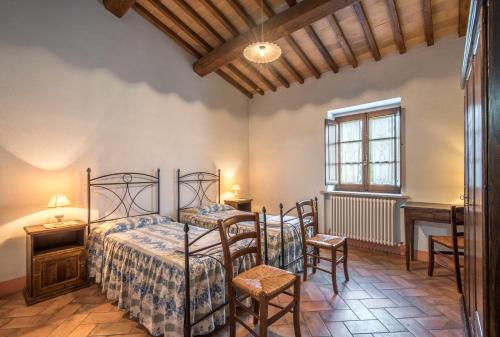 1 dormitorio con 2 camas, mesa y sillas en Villa Agriturismo Il Pratone, en Castiglione dʼOrcia