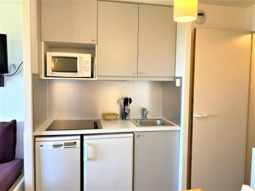 une petite cuisine avec un évier et un micro-ondes dans l'établissement Studio cabine 4 pers, vue, wifi, casier à ski - Avoriaz - FR-1-314-168, à Avoriaz