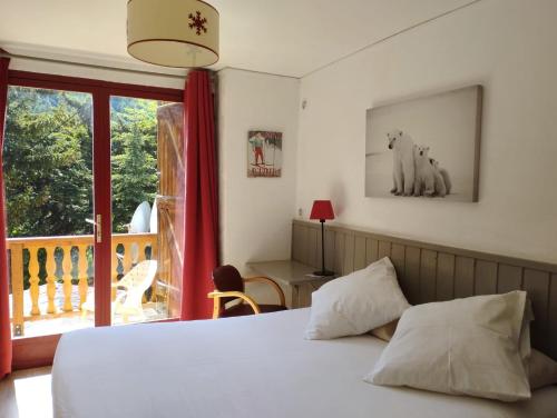 a bedroom with a bed and a balcony at Hotel La Source in La Foux