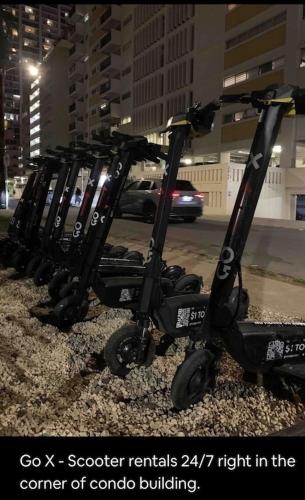 a row of scooters parked next to a street at Waikiki Condo 2 Bedrooms 2 Bathrooms with 1 free parking space in Honolulu