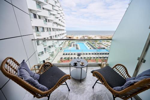 a balcony with chairs and a view of the ocean at Japandi Queen Std - Infinity Pool & Spa Resort in Mamaia Nord