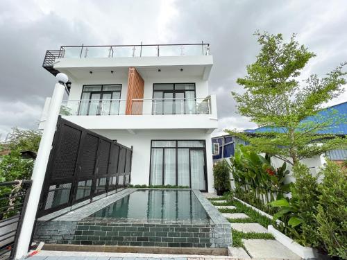 a house with a swimming pool in front of it at The Rivera Kampot in Kampot