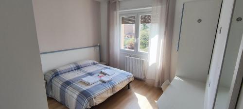 niewielka sypialnia z łóżkiem i oknem w obiekcie VROOM510 w Weronie