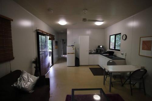 a living room with a table and a kitchen at Family Friendly in Howard Springs