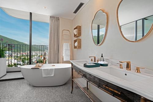 a bathroom with a large tub and a large window at L'amor Boutique Hotel Quy Nhơn in Quy Nhon