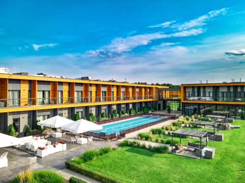 uma imagem do pátio de um hotel com piscina em Hotel Bonifacio SPA&SPORT Resort em Sochocin