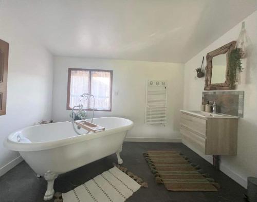 a white bathroom with a tub and a sink at Au Bien Hêtre in Futeau