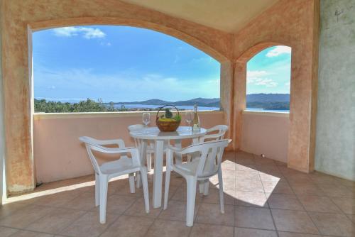 a white table and chairs on a balcony with a view at La Costa View in Arzachena