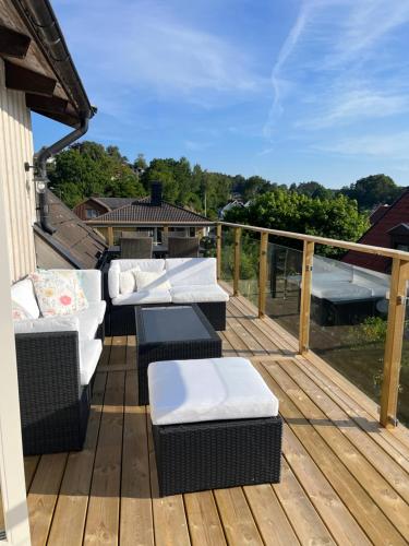 a deck with couches and chairs on a balcony at Villa nära till natur och stan in Gothenburg
