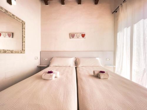 Dos camas en un dormitorio con toallas. en En plena naturaleza a 800m Playa Migjorn en Playa de Migjorn