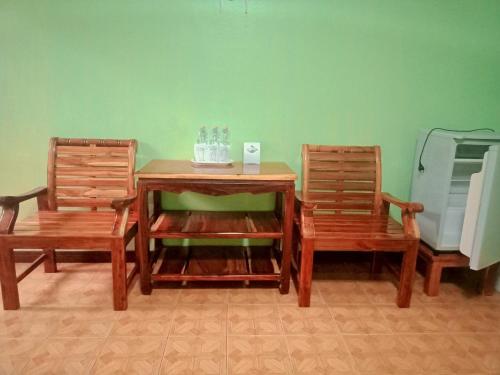 duas cadeiras e uma mesa de madeira com uma mesa e duas cadeiras em บ้านนารีสอร์ท em Nakhon Nayok