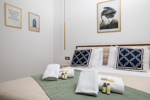 1 dormitorio con 1 cama con toallas en Twins Amphitheatre Apartments, en Pula