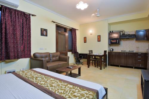 ein Hotelzimmer mit einem Bett und einem Wohnzimmer in der Unterkunft Studio Serviced Apartments near Fortis Hospital in Gurgaon