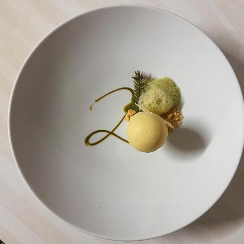 a white plate with some vegetables on it at Latemar - Hotel Suites Spa in Soraga