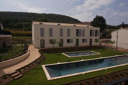 une maison avec 2 piscines dans une cour dans l'établissement Les Maisons de Gaugin Studio Le Lézard aan de voet van de Mont Ventoux, à Malaucène