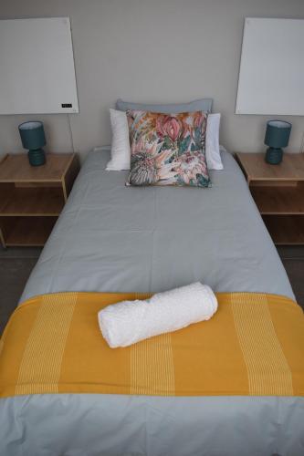 a bed with two towels sitting on top of it at Apple Orchard Cottage in Harrismith