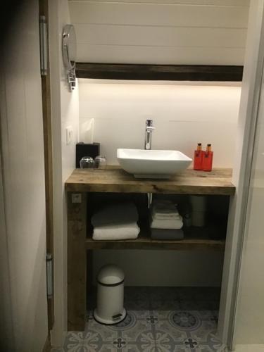 a bathroom with a sink and towels on a shelf at Stee 23 in Hertsberge