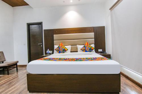 Schlafzimmer mit einem großen Bett mit einem Kopfteil aus Holz in der Unterkunft FabHotel Paradise Ville Resort in Bhīm Tāl