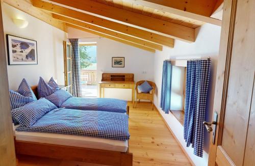 a bedroom with a blue bed and a wooden floor at Ferienhaus im modernen Landhauscharme mit Bergblick und Garten in Bischofswiesen