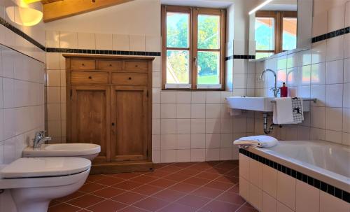 e bagno con servizi igienici, lavandino e vasca. di Ferienhaus im modernen Landhauscharme mit Bergblick und Garten a Bischofswiesen