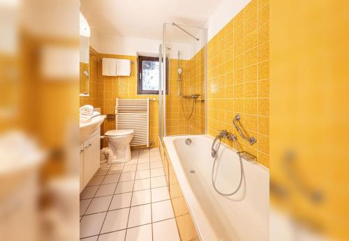 uma casa de banho com uma banheira, um WC e um lavatório. em Ferienwohnung Reserl in Bischofswiesen em Bischofswiesen